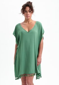 Abito kaftano verde realizzato in tessuto leggero, con scollatura a V e maniche corte, impreziosito da frange lungo l'orlo.