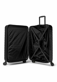Valise rigide noire avec une surface texturée, entièrement ouverte pour montrer un intérieur doublé, des sangles croisées pour sécuriser les objets, et des roues pivotantes.