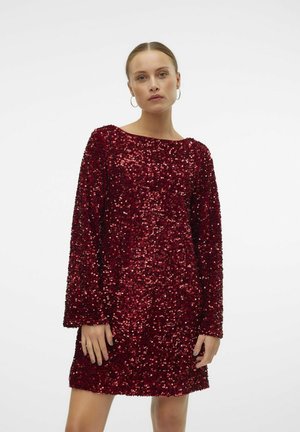 Abito rosso in paillettes con maniche lunghe, scollatura rotonda e superficie testurizzata. Lunghezza corta con una forma aderente, che mette in risalto una finitura lucida e riflettente.