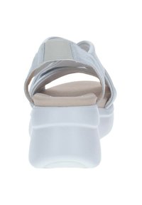 Sandalía gris clara con correas elásticas, plantilla acolchada, suela gruesa blanca y un diseño de espalda abierta, que muestra un upper texturizado.