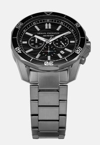 Sidabrinis nerūdijančio plieno laikrodis su juodu analoginiu ciferblatu, chronografo subdialais ir šviesą atidarančiomis rodyklėmis. Turi datos rodymą ir 100 metrų vandeniui atsparumą.