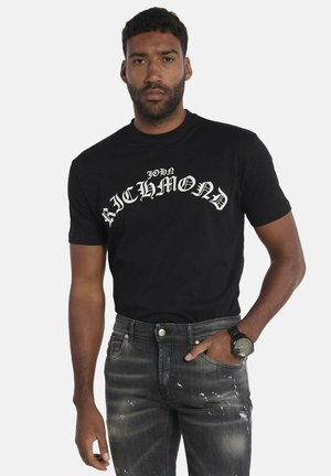 T-shirt in cotone nero con colletto a girocollo, caratterizzata da testo stampato bianco "JOHN RICHMOND" in un font stilizzato sul petto.