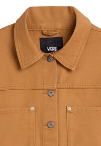 Chaqueta marrón con cuello, que presenta botones de presión plateados y un bolsillo en el pecho. Fabricada con un tejido duradero, resaltando un acabado texturizado.