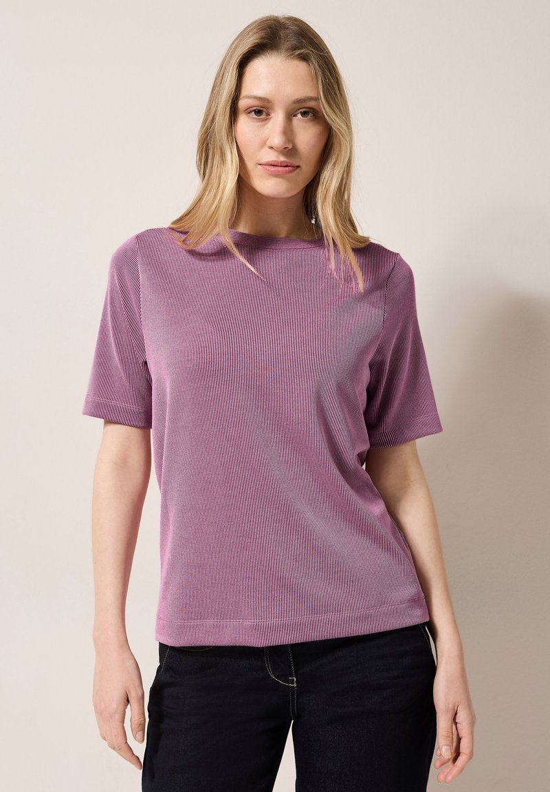 T-shirt viola a maniche corte con scollatura rotonda, caratterizzato da una texture liscia e una vestibilità comoda, abbinato a jeans scuri.