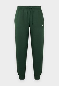 Zaļas sporta bikses ar elastīgu jostu, auklu un aprocēm potītēs. Augšējā kreisajā kājas daļā redzams mazs balts logo.