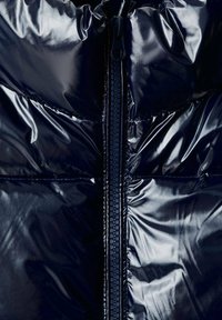 Marinblå, glänsande puffjacka med central dragkedja, kviltad textur och rynkad krage för ökad isolering och stil.