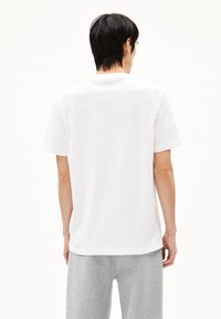 Witte katoenen T-shirt met een ronde hals en korte mouwen, met een rechte snit en een klein logotag aan de onderzijde.