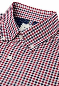 Rød, hvid og marineblå ternet skjorte med button-down krave, lavet af stof med et lille rutenetmønster og perle-lignende knapper.
