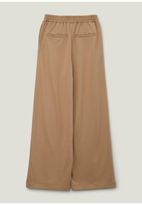 Beige wijde broek met een elastische tailleband, voorzien van twee achterzakken en een gladde, gestructureerde stof. Casual en losvallend ontwerp.