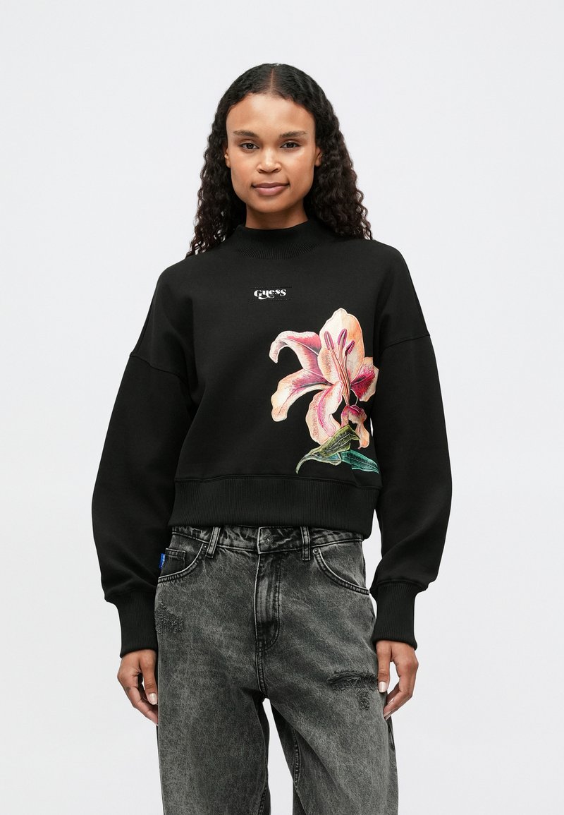 Sudadera negra de algodón, con un diseño de lirio rosa bordado en la parte frontal, con cuello alto y mangas anchas.