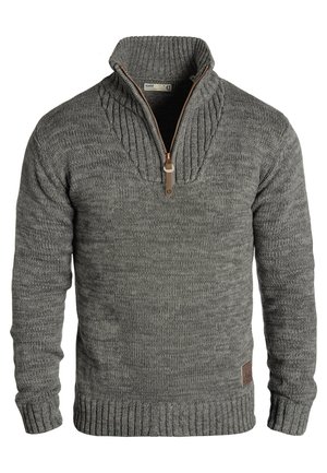 Maglione grigio lavorato a maglia con colletto alto, dotato di chiusura a zip parziale, polsini a coste e un motivo testurizzato. Dettaglio in pelle sul lato.