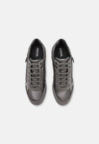 Grå lädersneakers med texturerade detaljer, fem öglor för snörning, sidodragkedja och gummisula. Varumärkeslogotyp på innersulan.