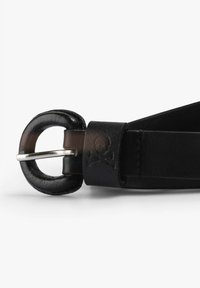 Cinturón de cuero negro con una hebilla redonda y un pasador de metal plateado. El cinturón tiene una textura suave y un sutil diseño de calavera cerca de la hebilla.