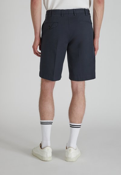 Pantaloni corti blu navy realizzati in misto cotone, con vita piatta, tasche laterali e una tasca posteriore con bottone. Orli arrotolati e vestibilità dritta.