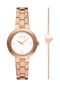 Roséguld metallklocka med rund boett och vit urtavla, minimalistiska markörer och matchande armband. Åtföljs av en kedja med ett hjärta i roséguld.