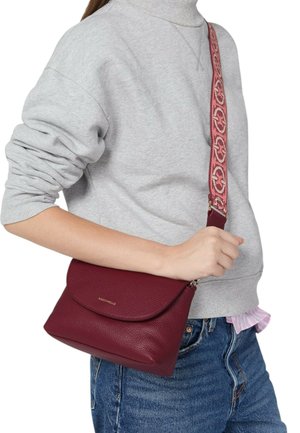 Burgundská kožená kabelka přes rameno s texturovaným povrchem, zaobleným klopovým zapínáním a vzorovaným nastavitelným popruhem s růžovými akcenty.