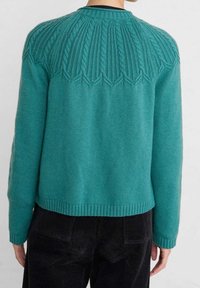 Turkusowy sweter z teksturowanym wzorem warkocza na plecach, z zaokrąglonym dekoltem oraz ściągaczami na rękawach i dole. Miękka mieszanka wełny.