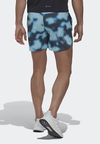 Shorts de bain pour hommes en bleu et noir tie-dye, longueur genou, avec un tissu léger et un accent logo subtil sur le côté.