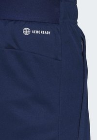 Námornícke modré šortky z textúrovaného materiálu majú zipsovú vrecko a bíle logo Aeroready. Dizajn zahŕňa hladký pás.