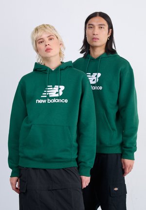 Sudadera con capucha verde que presenta un bolsillo canguro frontal y un logotipo "New Balance" en blanco. Confeccionada en un tejido texturizado y con puños acanalados.