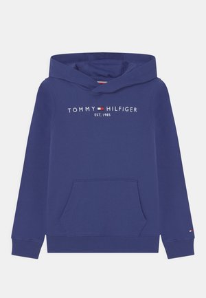 Granatowa bluza z kapturem z przednią kieszenią typu kangurek. Zdobiona haftowanym napisem "TOMMY HILFIGER EST. 1985" oraz charakterystycznym logo flagi na rękawie.