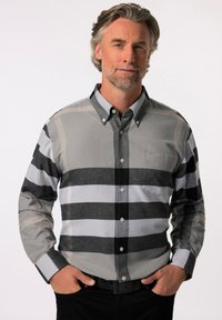 Camisa de cuadros en gris y negro con un único bolsillo en el pecho. Hecha de una tela suave, presenta rayas anchas y estrechas alternas.