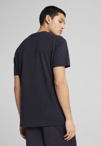 Navyblauwe katoenen t-shirt met een ronde hals, korte mouwen en een rechte zoom. De stof is glad en lichtgewicht.