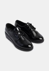 Schwarze Schnürschuhe mit glänzender Lackleder-Oberfläche, runder Zehenform und einem niedrigen Keilsohle, ausgestattet mit einer strukturierten Oberfläche und stabilen Schnürsenkeln.