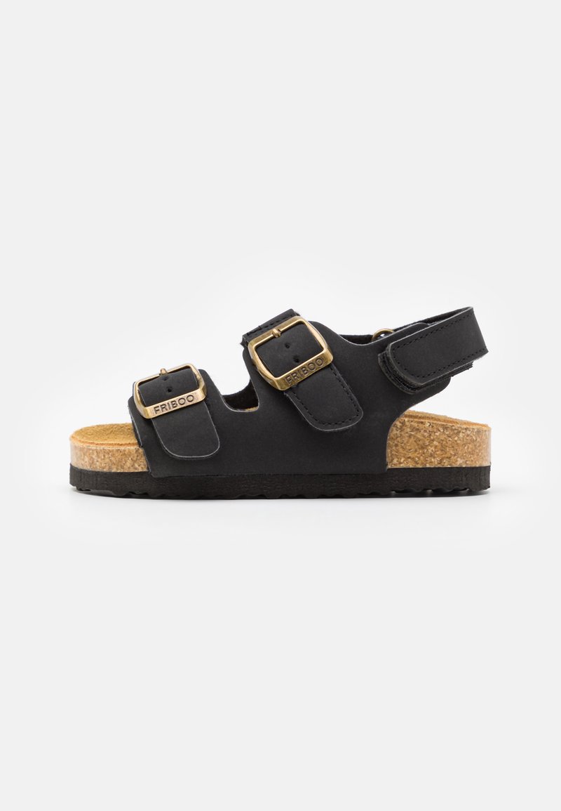 Svart sandal med doble justerbare spenner, korkfotbed og teksturert gummisåle. Åpen bakdesign for enkel påføring.