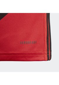 Maglia sportiva rossa in tessuto testurizzato, con accenti neri e il marchio "AEROREADY" vicino all'orlo. Strisce verticali sui lati.