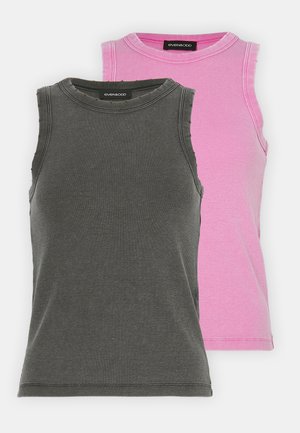 Due maglie a canottiera a coste esposte insieme; una in grigio scuro e una in rosa chiaro. Entrambe presentano scollature tonde e design senza maniche.