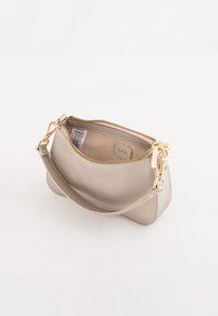 Bolso de mano metálico dorado con textura suave, cierre de cremallera, strap único y un sutil logotipo en el interior. Forma ligeramente redondeada.