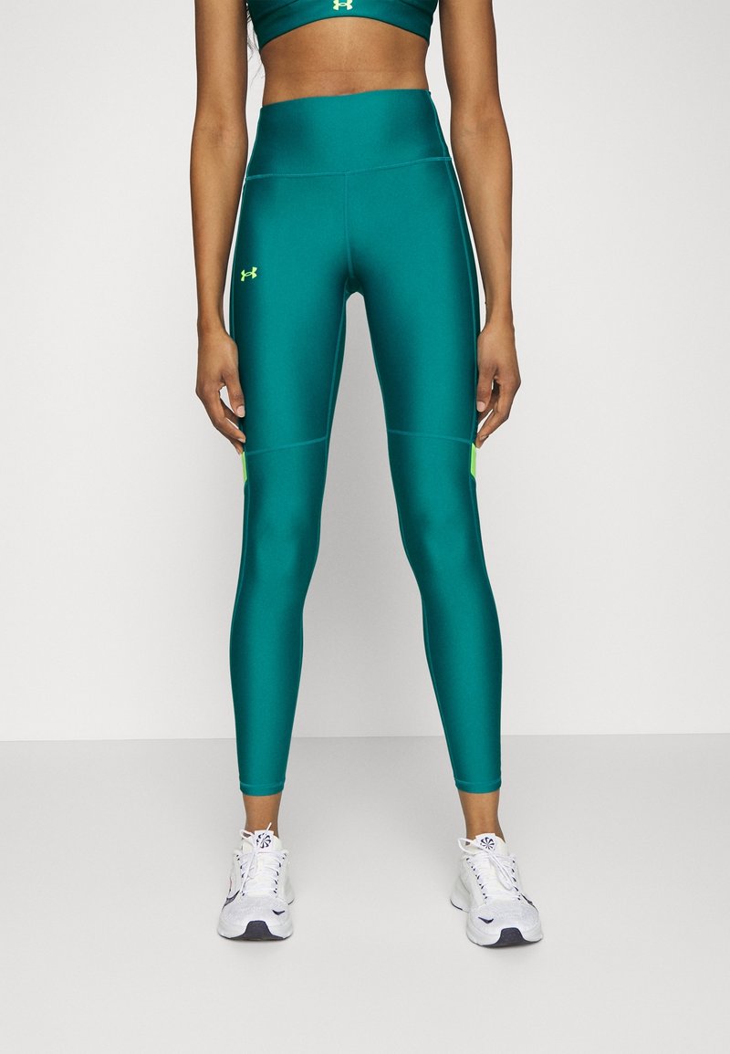Leggings compressivi color teal con vita alta e accenti verde neon a contrasto. Realizzati in un materiale liscio e elasticizzato, offrono un look aderente.