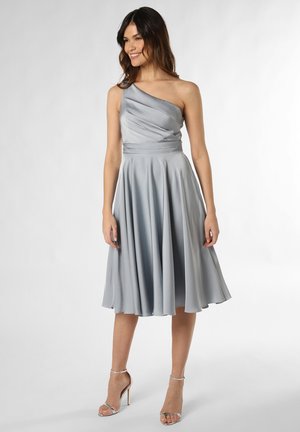 Ein schulterfreies, hellgraues Kleid mit gefälteltem Oberteil und ausgestelltem Rock, aus glattem Stoff, kombiniert mit silbernen, verschnürten Absätzen.