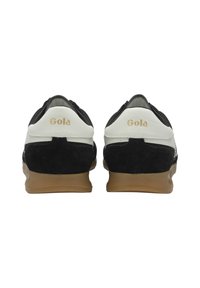 Black suede and white leather sneakers with tan rubber sole, featuring a minimalist design and embossed "Gola" logo in gold on the heel.