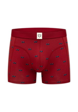 Røde herre boxershorts med spredte små blå solbrillemønstre og en hvid mærkat med en sort løvelogo på linningen.