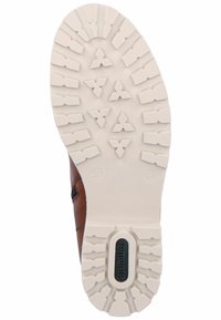 Brązowy skórzany but z białą gumową podeszwą, z fakturowanym wzorem bieżnika oraz czarnym logo marki na spodzie podeszw.