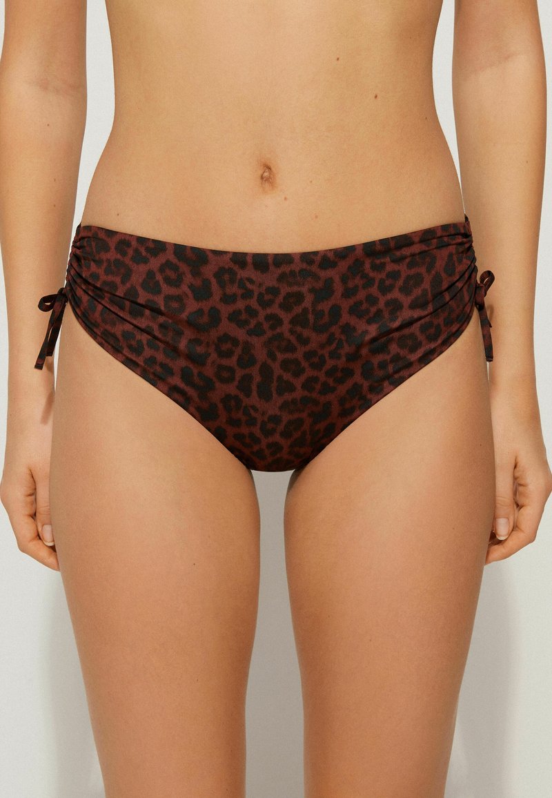 Bikini spodní část v leopardím vzoru v tmavě hnědých a černých tónech, s nařasením po stranách a nastavitelnými tkaničkami pro lepší přilnutí. Hladká textilie.