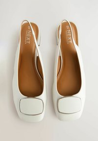 Escarpins blancs à bride arrière avec un bout carré et un accent argenté. Tige synthétique lisse et semelle intérieure rembourrée marron. Design minimaliste.