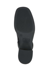 Suela de zapato negra con patrón de goma texturizada, con un tacón liso y una etiqueta de marca "Caprice". La superficie es mate sin adornos visibles.