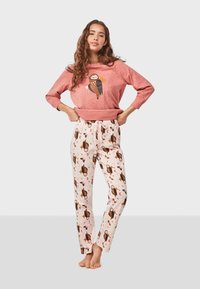 Pink sweatshirt with owl graphic, paired with cream pants featuring owl and star patterns, both in soft fabric and relaxed fit.