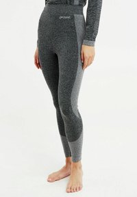 Leggings atletici grigi con vita alta, tessuto testurizzato e pannelli laterali in mesh. Presentano dettagli di cucitura e un logo sulla vita.