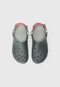 Schwarze Schaumstoffclogs mit Belüftungslöchern, geschwungenem Design, roten Akzenten am Riemen und strukturiertem Fußbett für guten Halt.