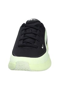 Zapatilla de Nike de malla negra con suela amarilla clara, vista frontal que muestra los cordones y los logotipos de la marca en la puntera y la lengüeta.