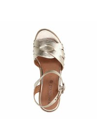 Gouden metallic sandaal met kruislings bandjesontwerp, verstelbare enkelriem en studdetails. Gladde textuur en open teen model.