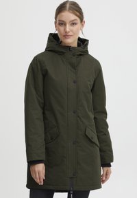 Veste à capuche vert olive avec des boutons à l'avant, deux poches latérales et une coupe longue dotée d'un cordon de serrage à l'ourlet. Texture lisse.