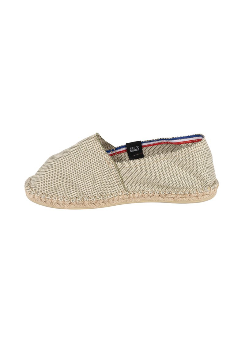 Chaussure beige en tissu à enfiler avec une surface texturée, une semelle en jute tressé et des rayures contrastantes rouge et bleu à l'intérieur de l'ouverture.