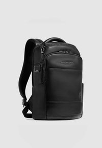 Sac à dos en cuir noir au design épuré, doté de plusieurs compartiments zippés, de bretelles réglables et d'un détail logo sur le devant.