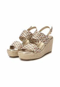 Sandalias de cuña con parte superior trenzada en dorado, blanco y marrón, que cuentan con una plataforma de yute texturizada, correa ajustable en el tobillo y plantilla suave y metálica.