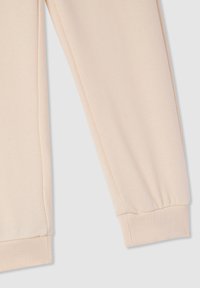 Felpa beige a maniche lunghe con polsini in elastico a coste su uno sfondo grigio chiaro.